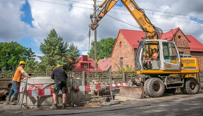 Robotnicy i koparka na budowie na Kłokoczycach