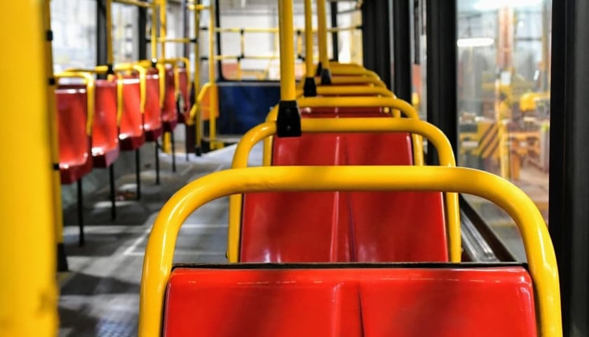 Stare, plastikowe czerwone siedzenia w tramwaju Konstal 105 