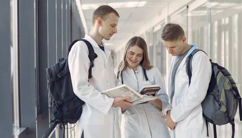 Na zdjęciu troje młodych ludzi w fartuchach lekarskich. Zdjęcie ilustracyjne