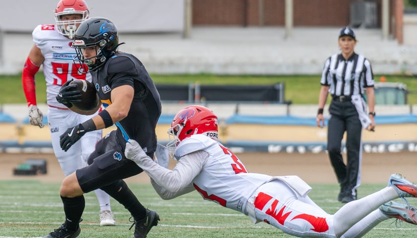 Dwóch zawodników futbolu amerykańskiego podczas akcji w meczu Panthers Wrocław - Firenze Red Lions 19 lipca na Stadionie Olimpijskim.