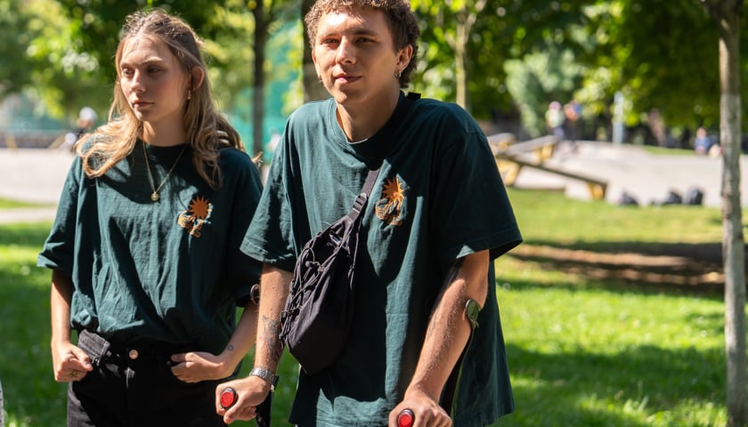 Kobieta i mężczyzna w zielonych koszulkach - to streetworkerzy, którzy będą rozmawiali z młodzieżą