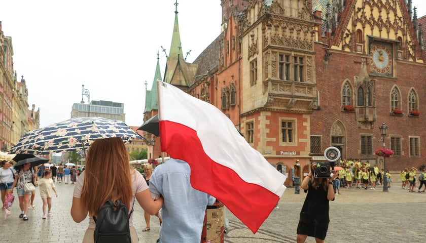 Para z biało-czerwoną flagą na Rynku we Wrocławiu, 1.08.2026 r.