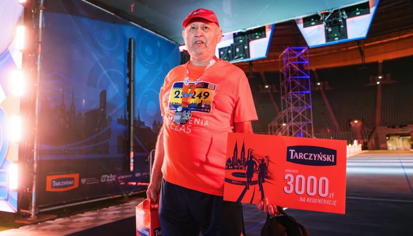 Pan Bronisław, na mecie nocnego półmaratonu trzyma duży kupon na wakacje