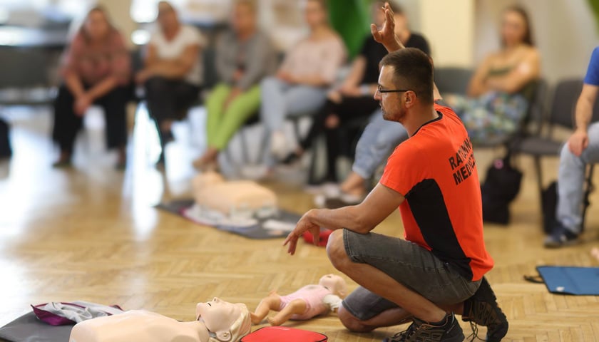 Kurs w siedzibie WCRS - na pierwszym planie ratownik z fantomem, w tle słuchacze. Zdjęcie archiwalne.