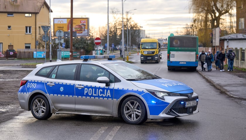 Policyjny radiowóz przy przejeździe kolejowym. Zdjęcie archiwalne, ilustracyjne.