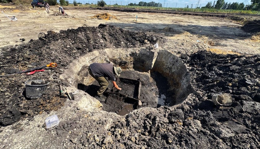 Archeolog w wykopie na terenie budowy przyszłych boisk sportowo-rekreacyjnych w Iwinach.