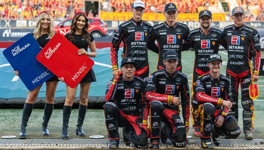 Wspólne zdjęcie zawodników Betard Sparty Wrocław z dwoma cheerleaderkami przed zwycięskim meczem z  Motorem Lublin na Stadionie Olimpijskim.
