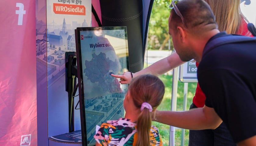 Piknik w parku parku im. Lesława Węgrzynowskiego. Na zdjęciu dziecko i dorośli biorą udział w grze