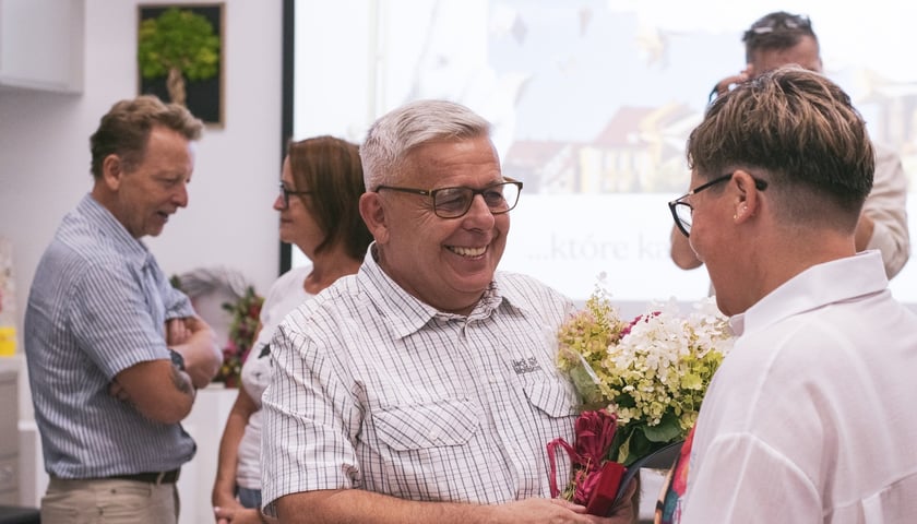 Jacek B. Myszkowski z bukietem kwiatów podczas uroczystości wręczenia nagrody