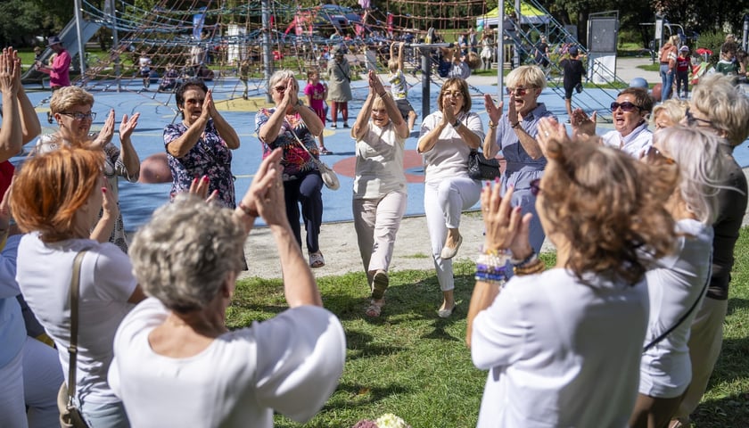 Piknik sąsiedzki na Hubach, 05.09.2026 Na zdjęciu tańczący w kręgu uczestnicy wydarzenia