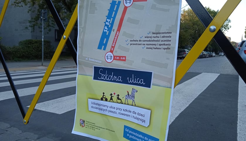 Plakat programu Szkolna Ulica na barierach zamykających wjazd na ulice przed placówkami