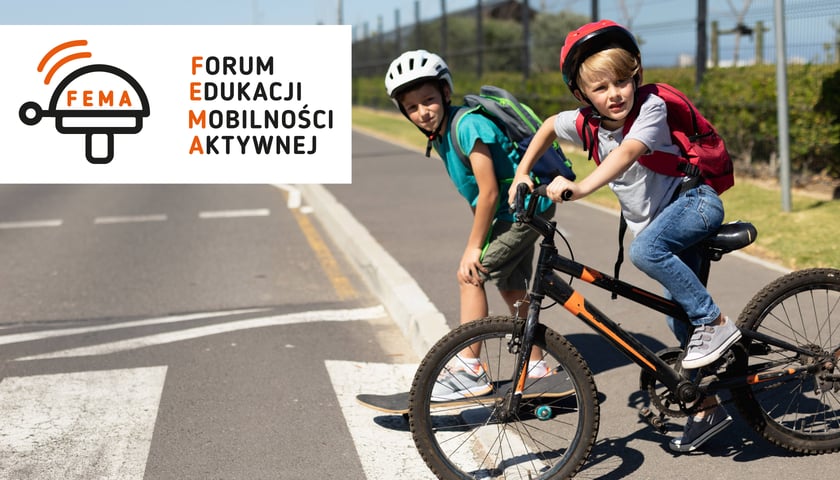 Dwoje dzieci na przejściu dla pieszych - jedno na rowerze, jedno pieszo