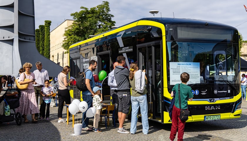 Druga edycja Aglomeracyjnego Pikniku Komunikacyjnego we Wrocławiu. Na zdjęciu nowoczesny autobus i grupka osób przy nim