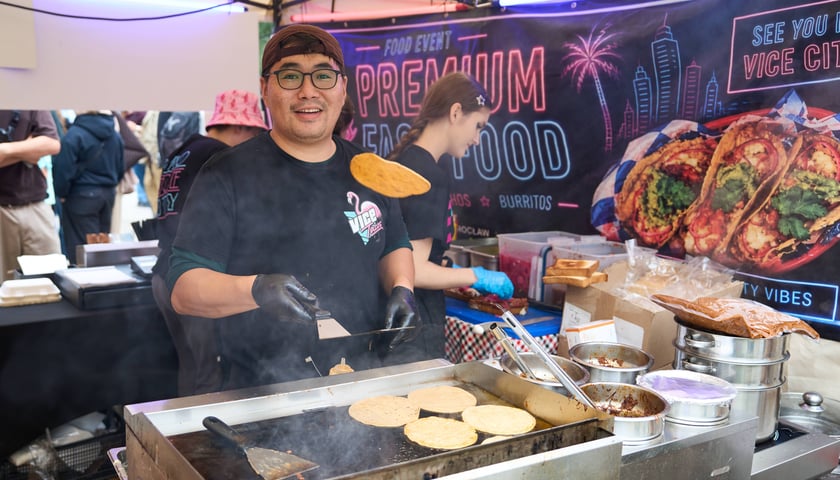 Finałowa edycja Gastro Miasto we Wrocławiu. Na zdjęciu młody uśmiechnięty mężczyzna przy grillu