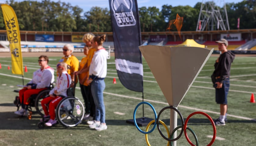 Piąta edycja Wrocławskiej Integracyjnej Olimpiady Sportowej na Stadionie Olimpijskim. Na pierwszym planie znicz olimpijski. 