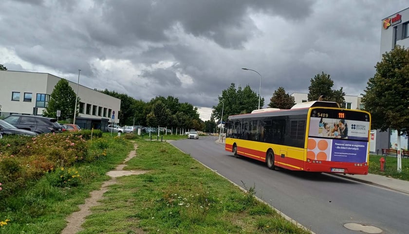 Miejsce przy Cynamonowej, gdzie brakuje chodnika. Widać autobus miejski jadący Cynamonową
