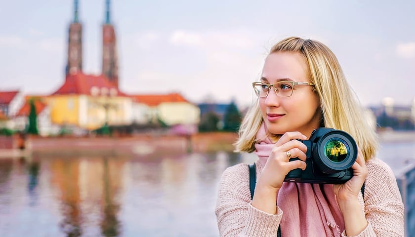 Kobieta z aparatem fotograficznym w rękach, zdjęcie ilustracyjne