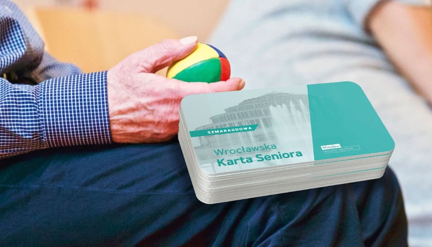 w tle: ręka starszego mężczyzny trzymająca kolorowa piłeczkę do rehabilitacji; w prawej części grafiki: stos plastikowych karty z napisem "Wrocławska Szmaragdowa Karta Seniora"