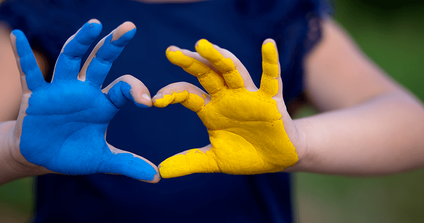 dwie złączone dłonie w niebiesko-żółtych kolorach