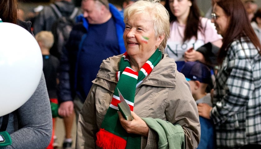 na zdjęciu starsza pani z wymalowaną na twarzy flag w barwach Śląska Wrocław