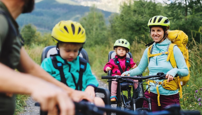 Na zdjęciu kobieta, mężczyzna i dzieci na rowerach w górach