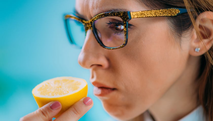 Na zdjęciu kobieta wąchająca cytrynę