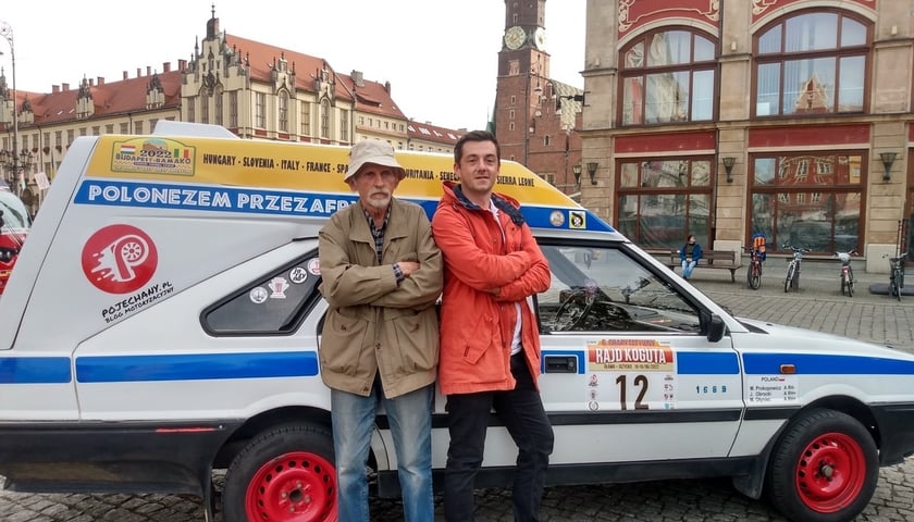 Na zdjęciu pilot - Julian Obrocki (z lewej) i kierowca - Marek Prokopowicz stoją przy wjeździe na wrocławski Rynek, oparci o poloneza, którym wezmą udział w rajdzie Budapeszt-Bamako.