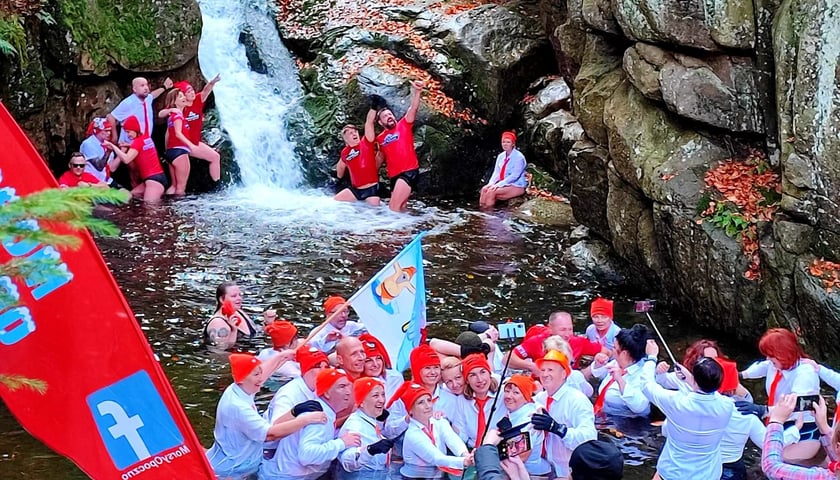 Morsy z Wrocławia rozpoczęły sezon w Karkonoszach. Na zdjęciu grupa ludzi kąpie się w zimnej wodzie, w wodospadzie w Przesiece