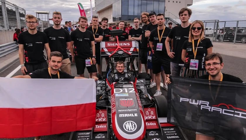 Członkowie Koła Naukowego PWr Ricing Team z bolidem RT12e 