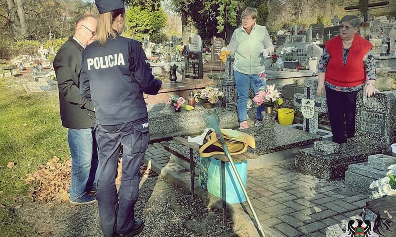 Na zdjęciu policjanci prowadzą akcję informacyjną na cmentarzu