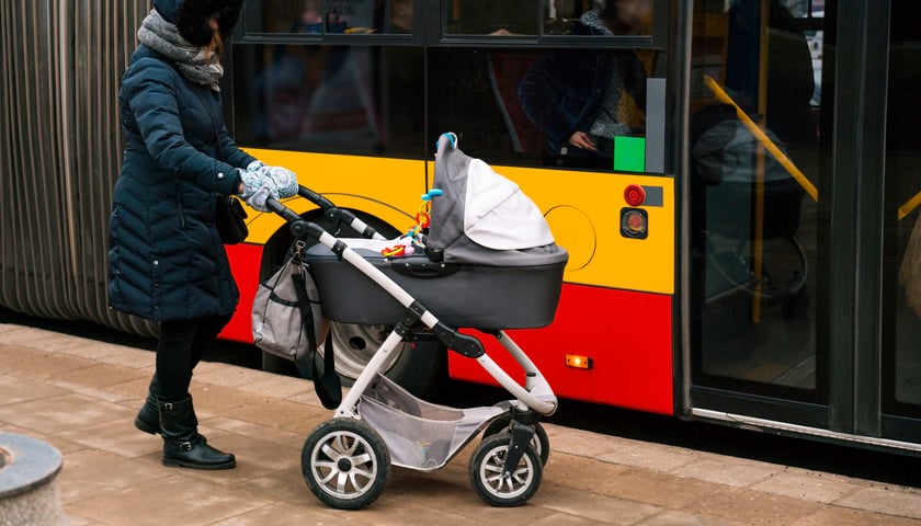 Na zdjęciu osoba wsiadająca z dziecięcym wózkiem do autobusu