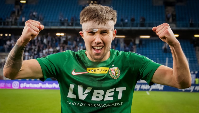 Na zdjęciu jest Daniel Leo Gretarsson. Mężczyzna trzyma ręce uniesione do góry w geście radości, na czole ma opatrunek
