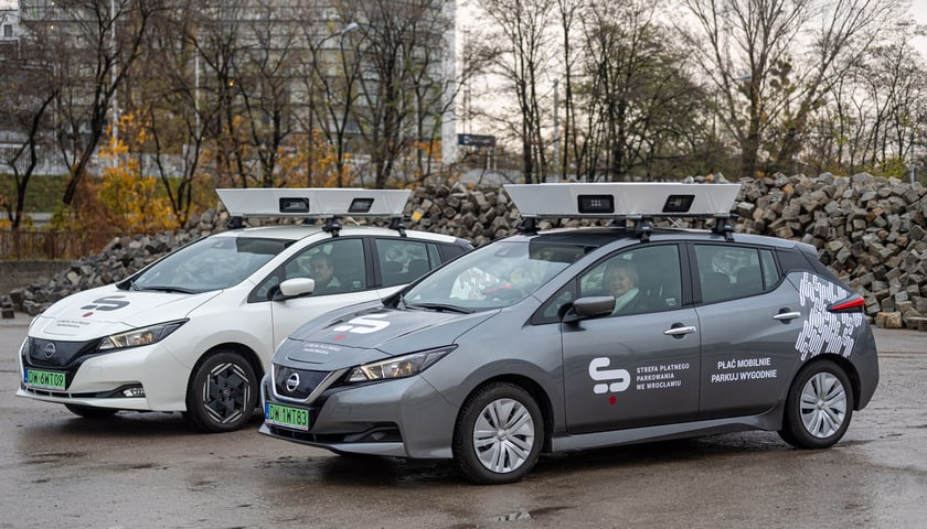 Na zdjęciu dwa samochody, oznakowane specjalnymi napisami, które prowadzą e-kontrole w strefach płatnego parkowania we Wrocławiu