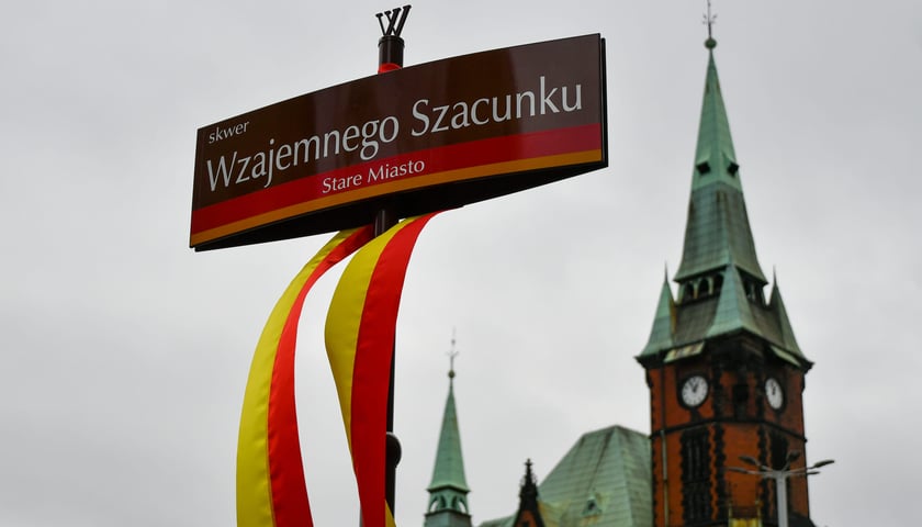 Na zdjęciu tabliczka z napisem "Skwer Wzajemnego Szacunku". W tle wrocławskie budynek dawnej Biblioteki Uniwersyteckiej 