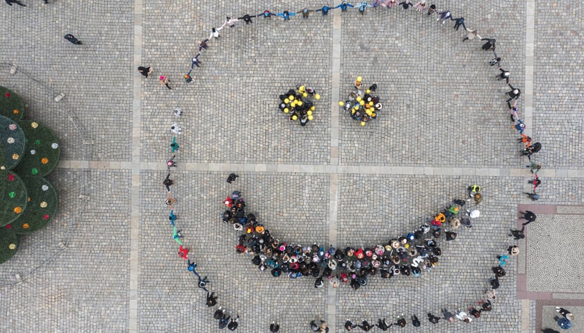 na zdjęciu z góry uśmiech "zrobiony" ze stojących na Rynku dzieci