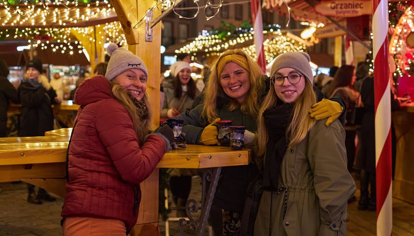 Na zdjęciu uśmiechnięte wrocławianki z kubkami świątecznego grzańca na Jarmarku Bożnoradzeniowym we Wrocławiu