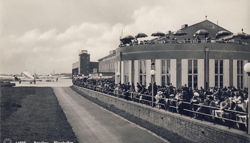 Lata 1938-1940, widok na budynki dawnego portu lotniczego na Gądowie Małym. W tle dawny hangar, obecnie przebudowany istnieje jako Jarmark Gądowski. Źródło: vorwerk / fotopolska.eu