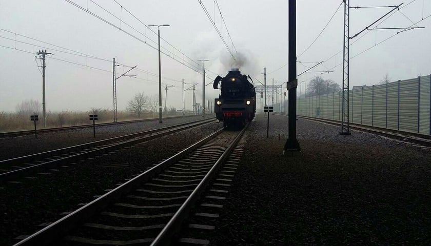 Na zdjęciu widać pociąg retro, który jedzie po torach