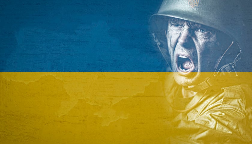 Na zdjęciu twarz żołnierza i flaga Ukrainy