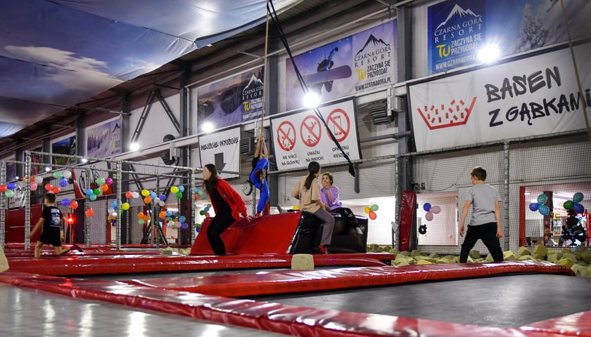 Na zdjęciu kompleks trampolin Jump World i grupa nastolatków bawiących się na trampolinach