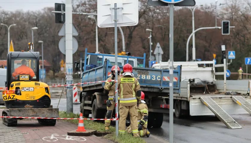 Na zdjęciu trzech strażaków zabezpieczających teren mostu Szczytnickiego po awarii gazociągu 6 grudnia 2022.