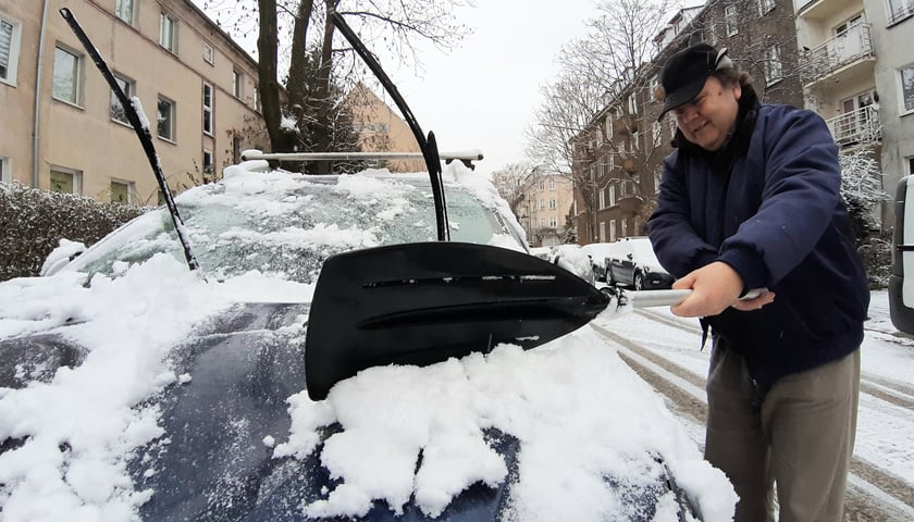 Każdy radził sobie dzisiaj rano z odśnieżaniem tak, jak umiał najlepiej. Niektórzy byli bardzo pomysłowi - jeden z mieszkańców Wrocławia zgarniał śnieg z samochodu... wiosłem (na zdjęciu) 