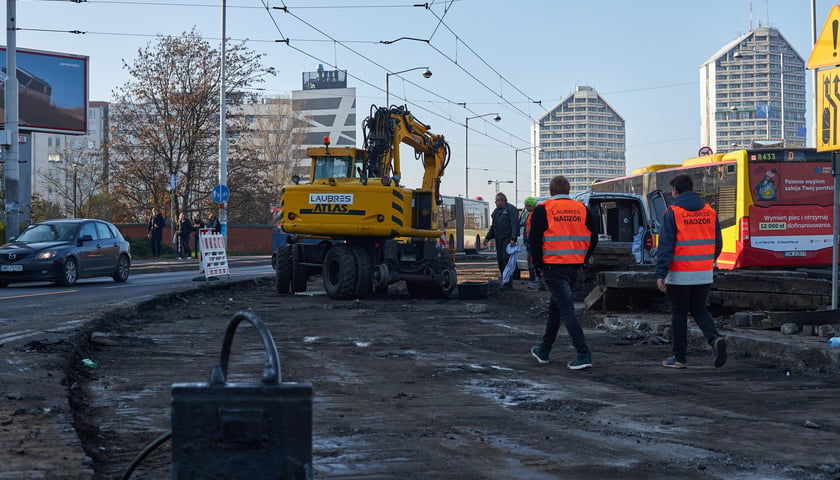 Na zdjęciu: dwójka mężczyzn i koparka na remontowanym fragmencie ulicy