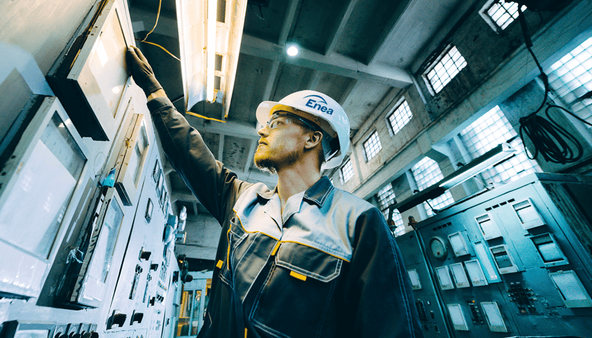 Na zdjęciu mężczyzna w kasku i okularach ochronnych w industrialnym pomieszczeniu