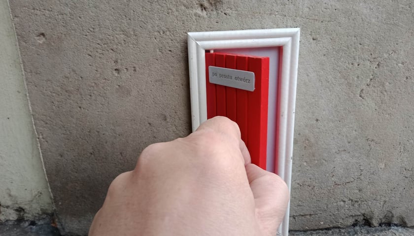 Drewniane, małe drzwiczki zwracają uwagę przechodniów na wrocławskim Rynku