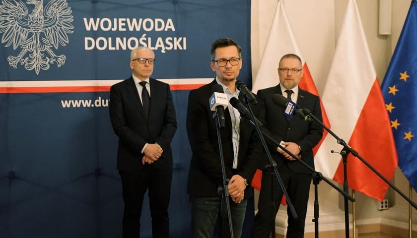 Na pierwszym planie zdjęcia: Daniel Gibski, wojewódzki konserwator zabytków na Dolnym Śląsku, przed mikrofonami w urzędzie wojewódzkim