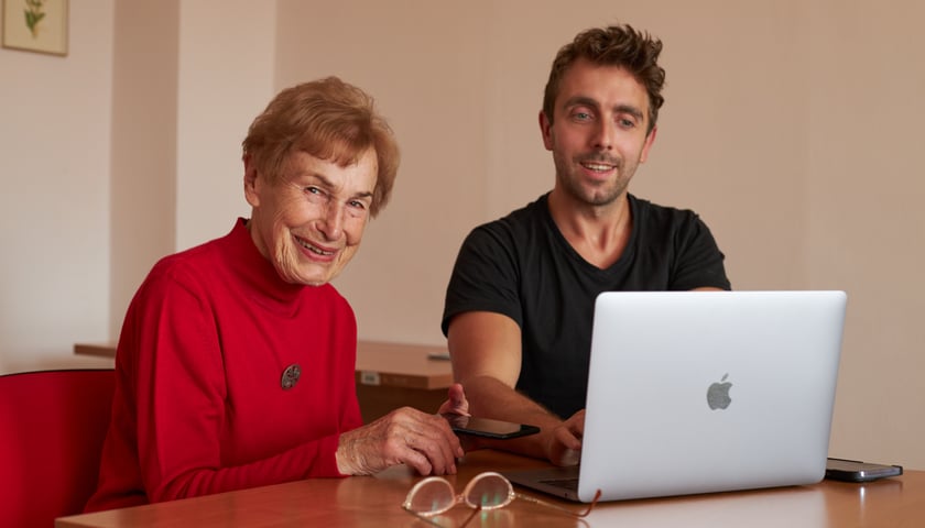Seniorzy chętnie uczą się nowych rzeczy, nie chcą być wykluczeni cyfrowo. Na zdjęciu jedna z wrocławskich seniorek  siedząca przy laptopie obok mężczyzny prowadzącego zajęcia