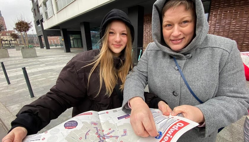 Na zdjęciu dwie kobiety z biuletynem wroclaw.pl otwartym na stronie, gdzie wklejać można naklejki związane z inwestycjami we Wrocławiu