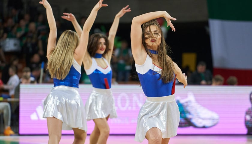 Na zdjęciu: trzy dziewczyny z zespołu Cheerleaders Wrocław podczas meczu w Hali Stulecia