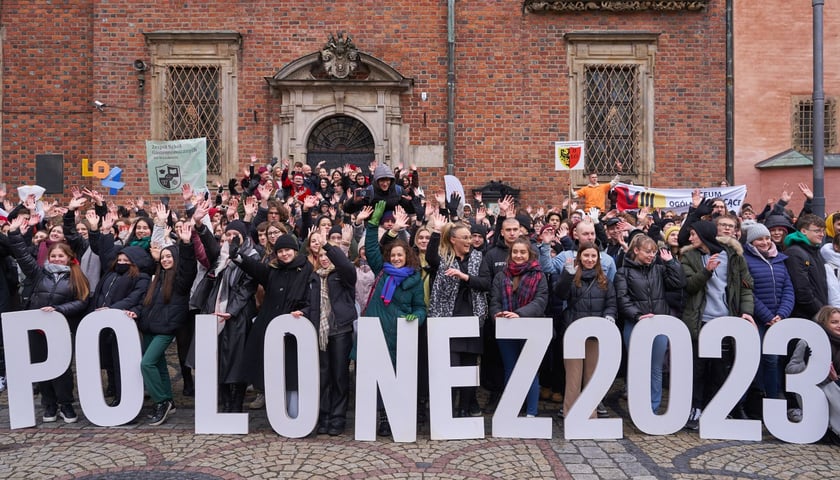 Uczestnicy Poloneza dla Fredry 2023 we wrocławskim Rynku. Z przodu napis "Polonez 2023"